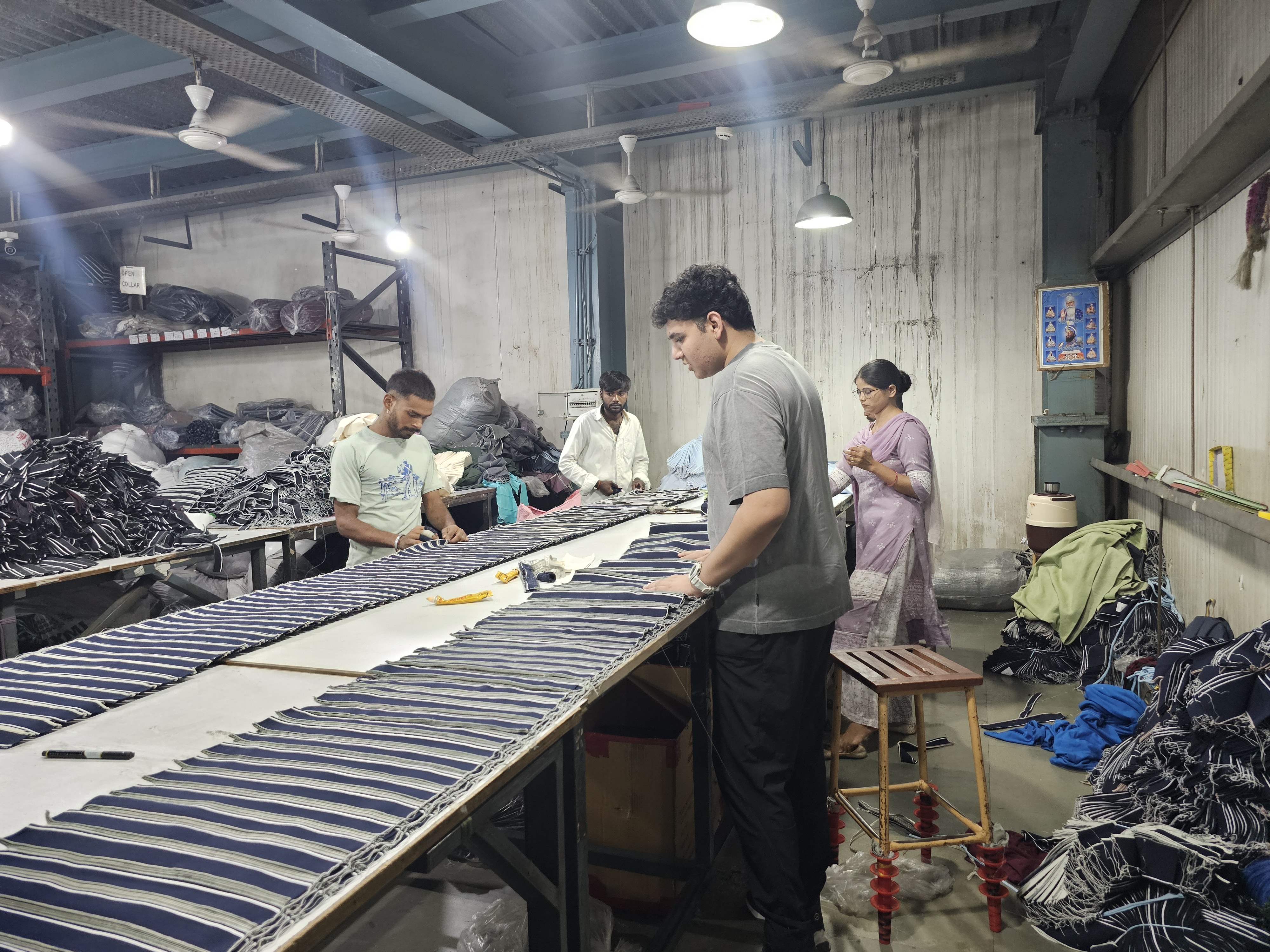 Factory floor with separated flat-knit output across tables